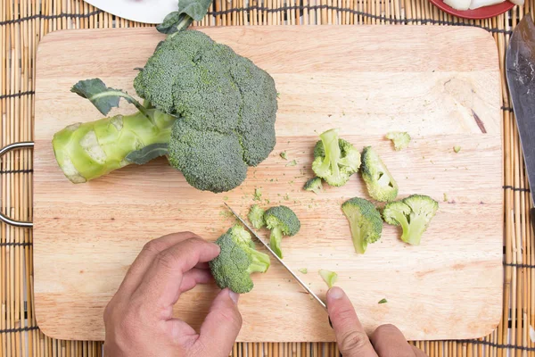 Chef-kok snijden broccoli vóór het koken met mes — Stockfoto