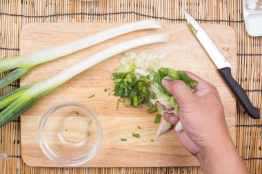 Yeşil soğan dilim kupasına koyarak Şef