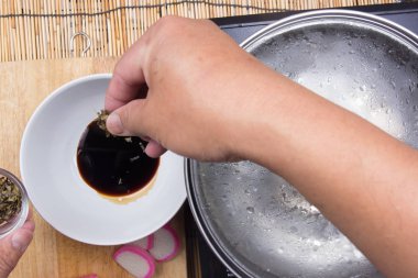 Şef soya sosu için kuru deniz yosunu koymak