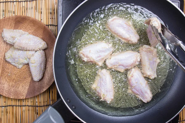 Chef-kok kippenvleugeltjes voor fring aanbrengend pan — Stockfoto