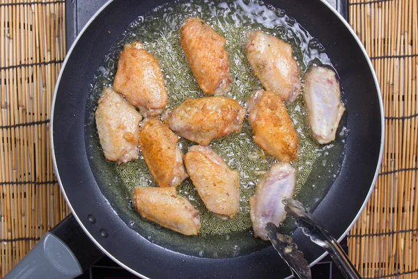 Chef-kok frituren Kippenvleugels in de pan — Stockfoto