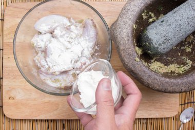 Yemek pişirmek için tavuk kanadı için un koyarak Şef