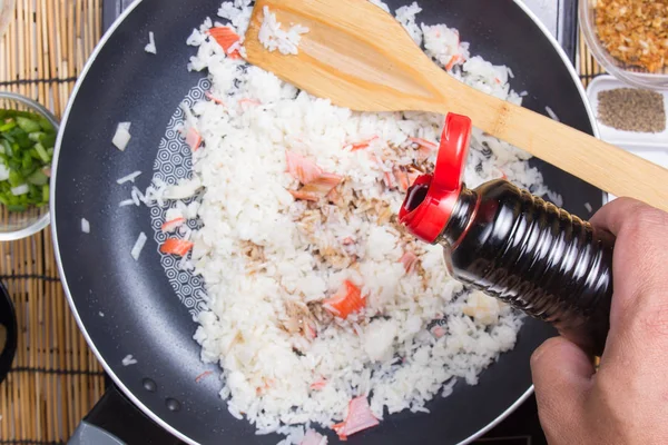 Шеф-повар добавляет соевый соус для приготовления риса — стоковое фото