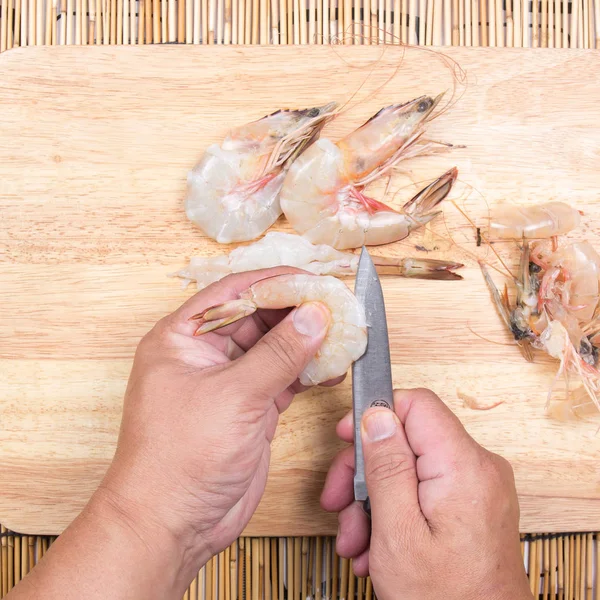Chef cozinhar camarão cru com faca Imagem De Stock