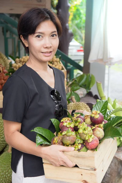 Ασιατικές γυναίκα με καλάθι φρούτων του mangosteen — Φωτογραφία Αρχείου