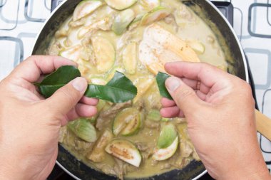 Şef paçavra Güney Afrika'da bir kabile kireç yaprakları yeşil köri yemek pişirmek için