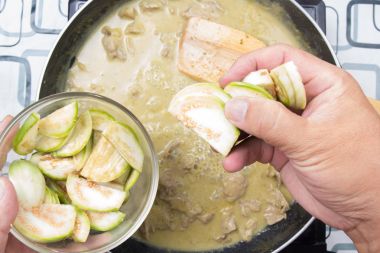 Yeşil köri yemek pişirmek için Tay Brinjal koyarak Şef