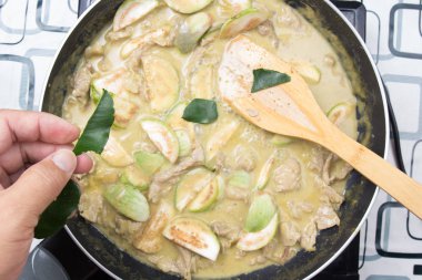 Şef paçavra Güney Afrika'da bir kabile kireç yaprakları yeşil köri yemek pişirmek için