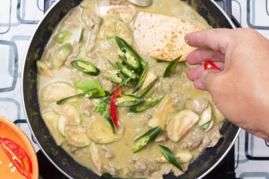 Yeşil köri yemek pişirmek için biber koyarak Şef