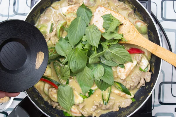 Yeşil köri yemek pişirmek için Tay fesleğen koyarak Şef