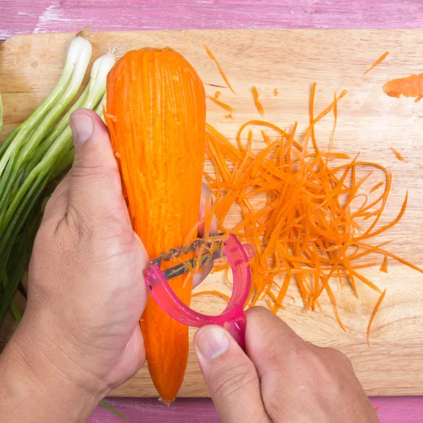 Chef mengupas dan memotong wortel — Stok Foto