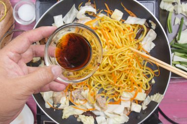 Şef soya sosu Yakisoba noodle yemek pişirmek için dökme