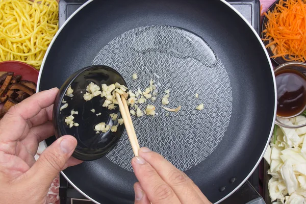 Chef mettendo aglio tritato per cucinare Yakisoba — Foto Stock