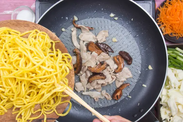 Chef poniendo fideos Yakisoba en la sartén — Foto de Stock