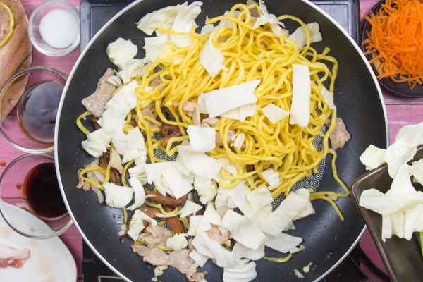 Şef Yakisoba noodle yemek pişirmek için lahana katmak