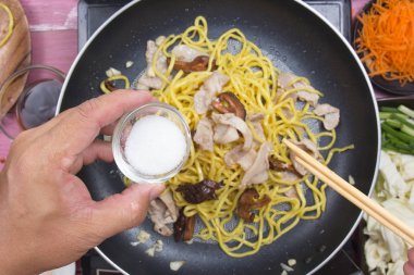 Şef Yakisoba noodle yemek pişirmek için şekeri