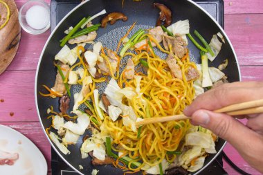 Şef stir fry Japon şehriye tavada