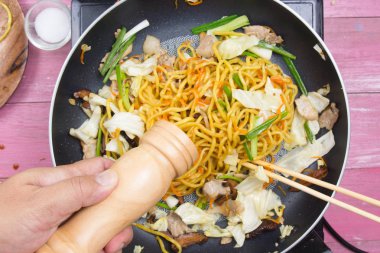 Şef Yakisoba noodle yemek pişirmek için biber koyarım