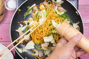 Şef Yakisoba noodle yemek pişirmek için biber koyarım