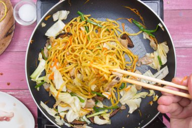 Şef stir fry Japon şehriye tavada