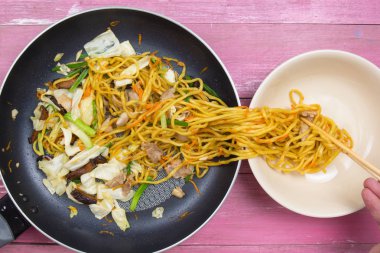 Şef stir fry Japon şehriye için kap koyun.