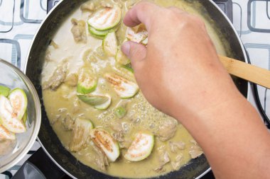 Yeşil köri yemek pişirmek için Tay Brinjal koyarak Şef