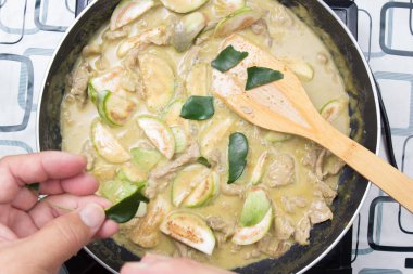 Şef paçavra Güney Afrika'da bir kabile kireç yaprakları yeşil köri yemek pişirmek için