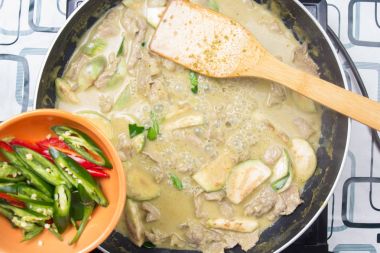 Yeşil köri yemek pişirmek için biber koyarak Şef