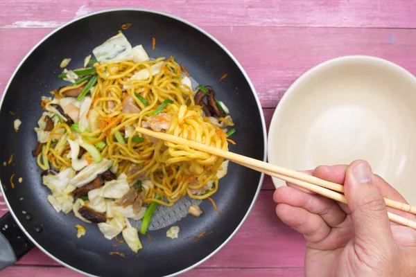 Şef stir fry Japon şehriye için kap koyun.