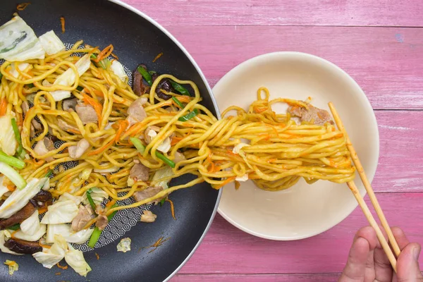 Şef stir fry Japon şehriye için kap koyun.