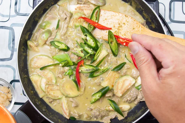 Yeşil köri yemek pişirmek için biber koyarak Şef