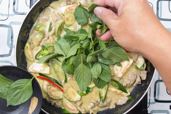 Yeşil köri yemek pişirmek için Tay fesleğen koyarak Şef