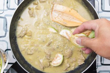 Yeşil köri yemek pişirmek için Tay Brinjal koyarak Şef