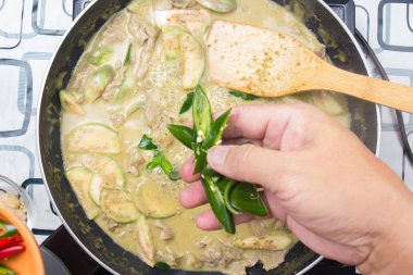 Yeşil köri yemek pişirmek için biber koyarak Şef