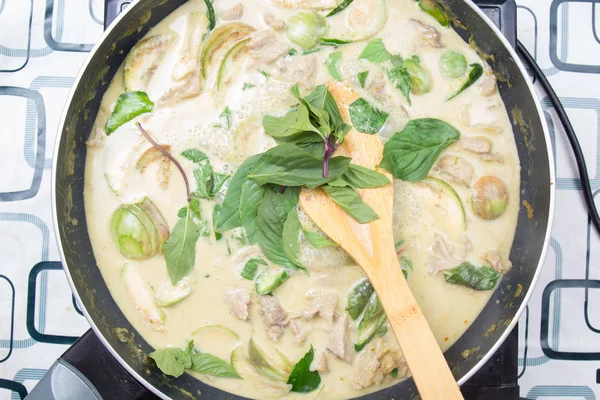 Yeşil köri yemek pişirmek için Tay fesleğen koyarak Şef