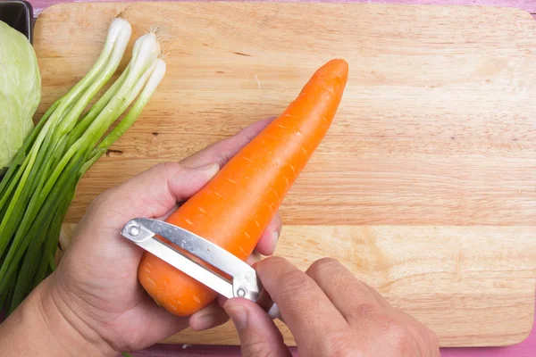 Chef éplucher la carotte de peau — Photo