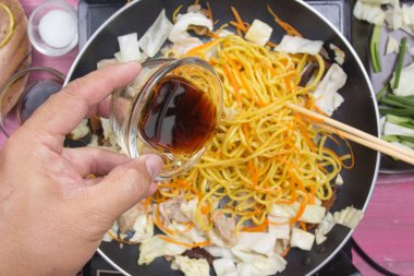 Şef soya sosu Yakisoba noodle yemek pişirmek için dökme