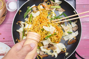 Şef Yakisoba noodle yemek pişirmek için biber koyarım