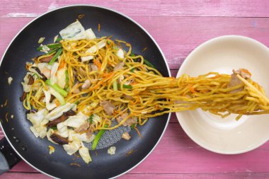 Şef stir fry Japon şehriye için kap koyun.