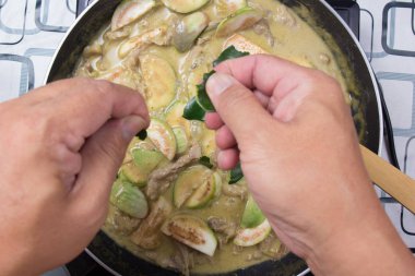 Şef paçavra Güney Afrika'da bir kabile kireç yaprakları yeşil köri yemek pişirmek için