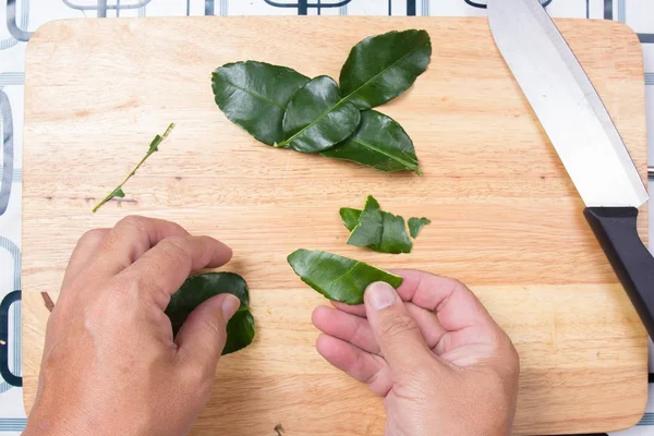 Chef-kok versnipperen kaffir-limoenblaadjes met de hand. — Stockfoto