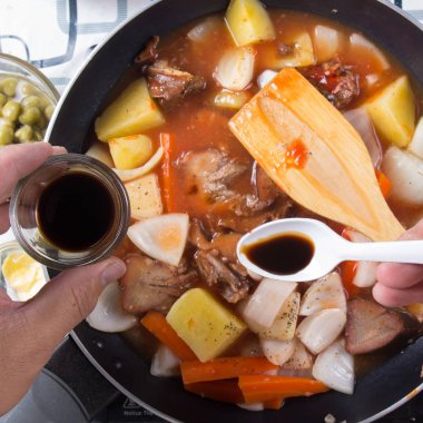 Yemek pişirmek için baharat sosu koyarak Şef