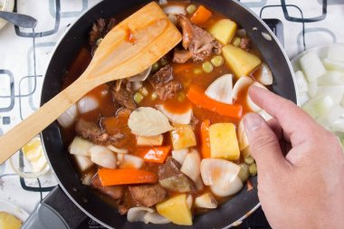 Yemek pişirmek için defne yaprağı koyarak Şef