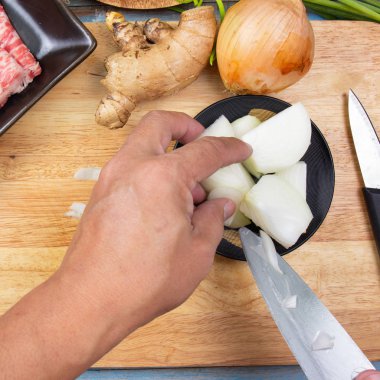 Aşçı pişirmeden önce soğan doğruyor.