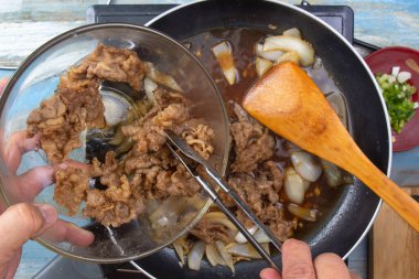 Şef tavaya bir dilim pişmiş et koydu.