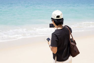 Genç bir kadın cep telefonuyla fotoğraf çekiyor.