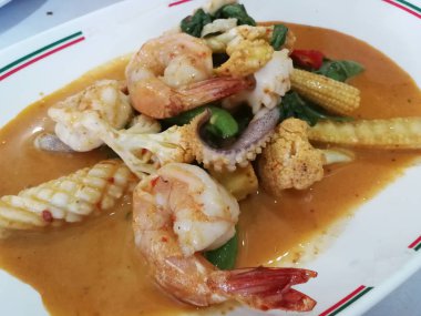 Kırmızı köri soslu kızarmış karides ve kalamar ve hindistan cevizi sütü. 