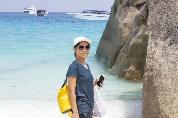 Молодая женщина держит мобильно ходить по морю — стоковое фото