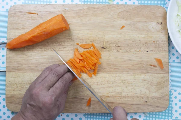 Chef is cutting carrots / Top view