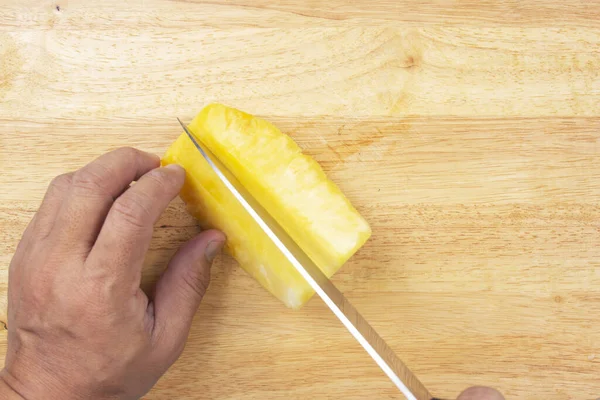 Cutting  pineapple with  knife on wooden board on top — Stock Photo, Image